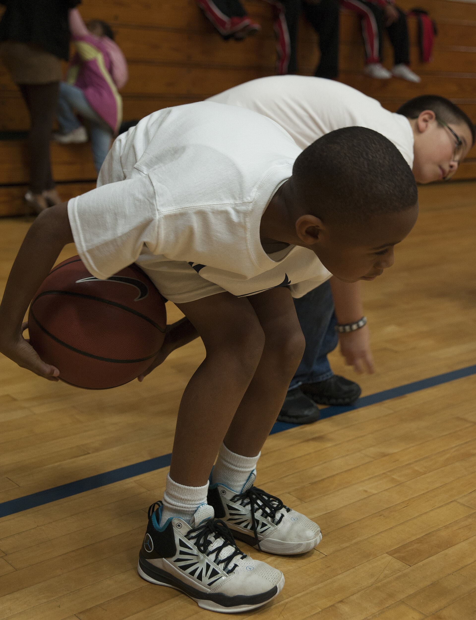 A child controlling a basketball during a youth clinic